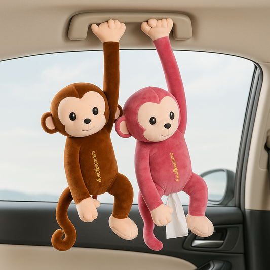 Two plush monkey toys hanging from a car's sun visor with a tissue paper.